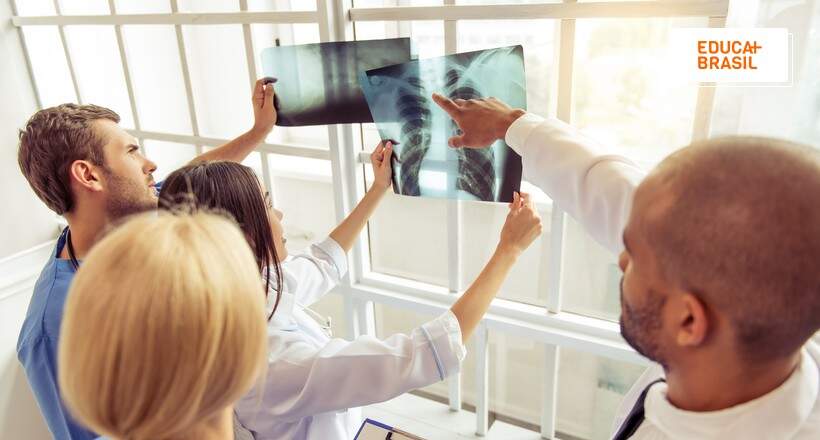 Médicos analisando raio-x de paciente que realiza fisioterapia cardiopulmonar.