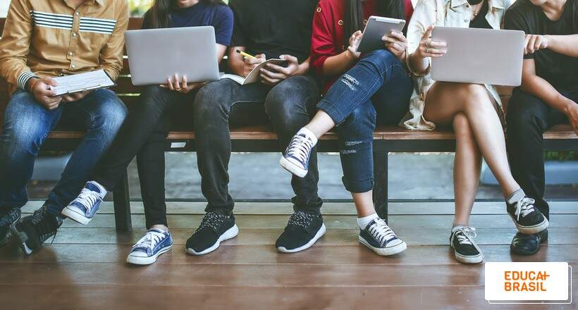 Estudantes sentados consultado online data do resultado do Encceja 2022. Estudantes sentados consultado online data do resultado do Encceja 2022.