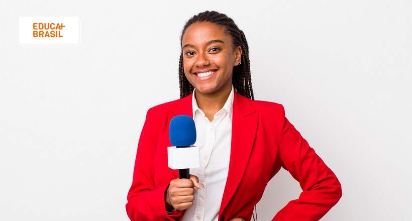 Jornalista sorrindo, vestida de vermelho e com microfone na mão. Jornalista sorrindo, vestida de vermelho e com microfone na mão.