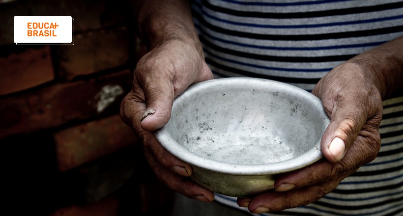 Pessoa que sofre de insegurança alimentar segurando prato vazio. Pessoa que sofre de insegurança alimentar segurando prato vazio.