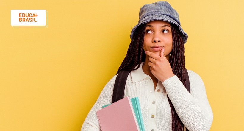 Estudante com livro nas mãos e expressão de dúvida sobre MBA em Gestão Pública. Estudante com livro nas mãos e expressão de dúvida sobre MBA em Gestão Pública.