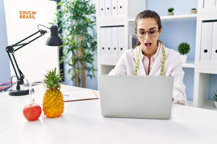 Nutricionista olhando para o notebook surpresa com a residência médica.