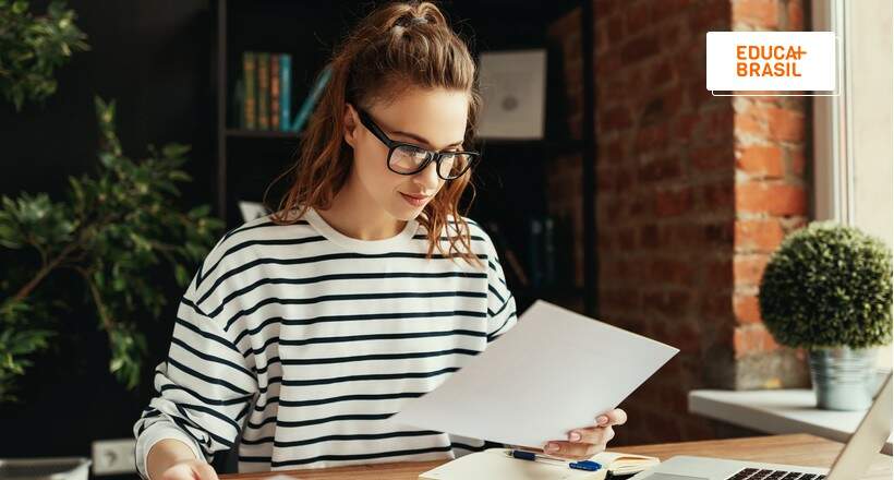 Estudante segurando documentos para comprovação de informações do Prouni. Estudante segurando documentos para comprovação de informações do Prouni.