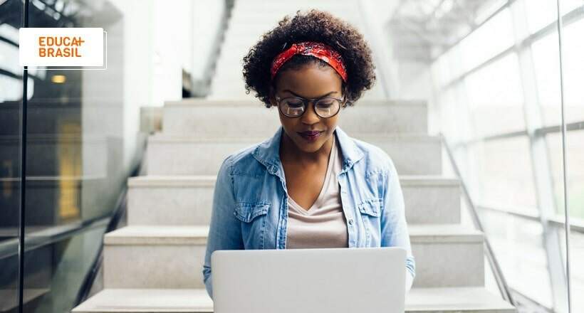 Estudante consultando no computador editais do Sisu, Prouni e Fies 2023.2. Estudante consultando no computador editais do Sisu, Prouni e Fies 2023.2.