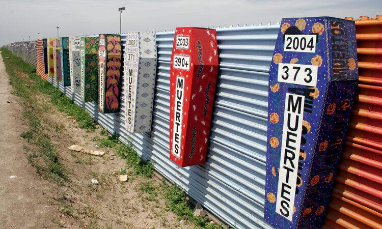 Caixões coloridos em muro que faz a barreira entre o México e os Estados Unidos Caixões coloridos em muro que faz a barreira entre o México e os Estados Unidos