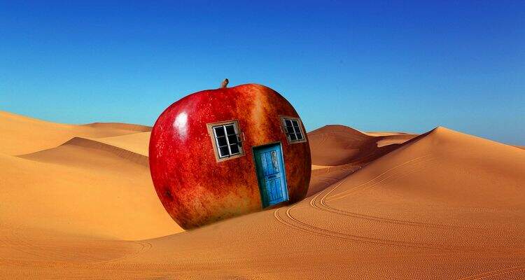 Uma maçã em formato de casa e no meio do deserto