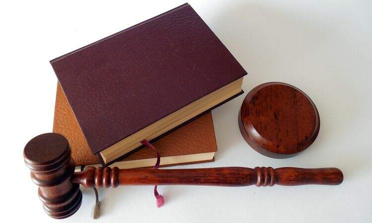 Livros ao lado do malhete, conhecido como martelo do juiz Livros ao lado do malhete, conhecido como martelo do juiz