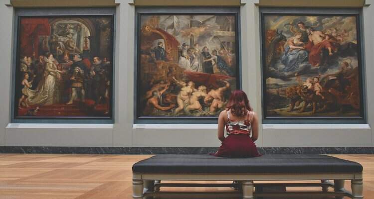 Mulher contempla obras em museu Mulher contempla obras em museu