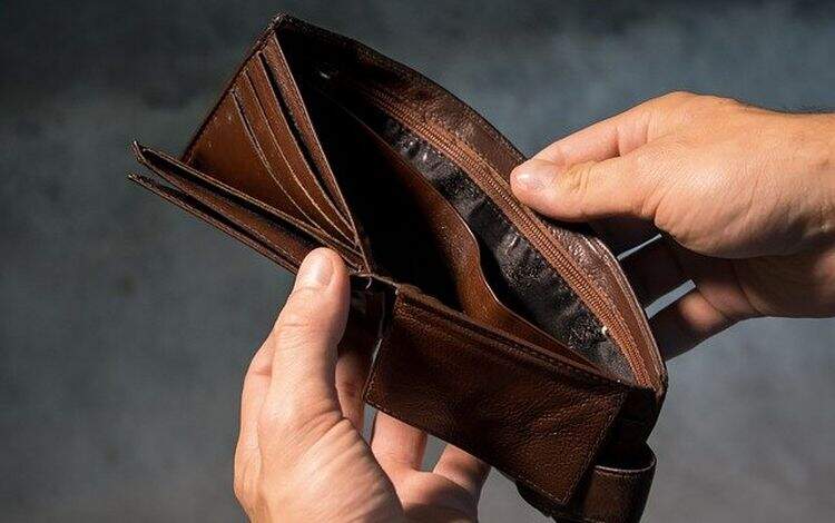 Homem segurando uma carteira vazia Homem segurando uma carteira vazia