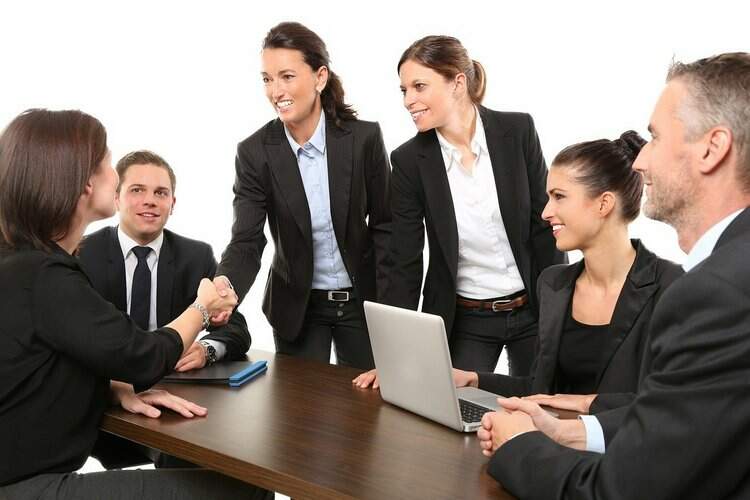 Pessoas se cumprimentam em ambiente corporativo Pessoas se cumprimentam em ambiente corporativo