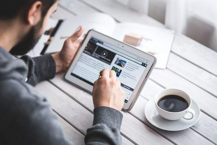 Um homem manuseia um tablet Um homem manuseia um tablet